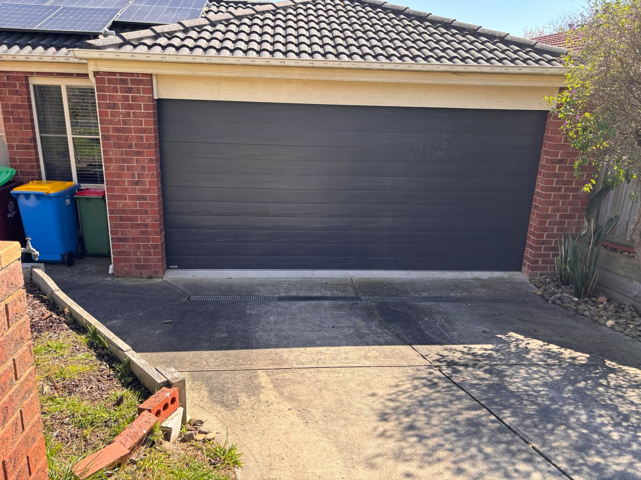 Dark sectional garage door on a brick home